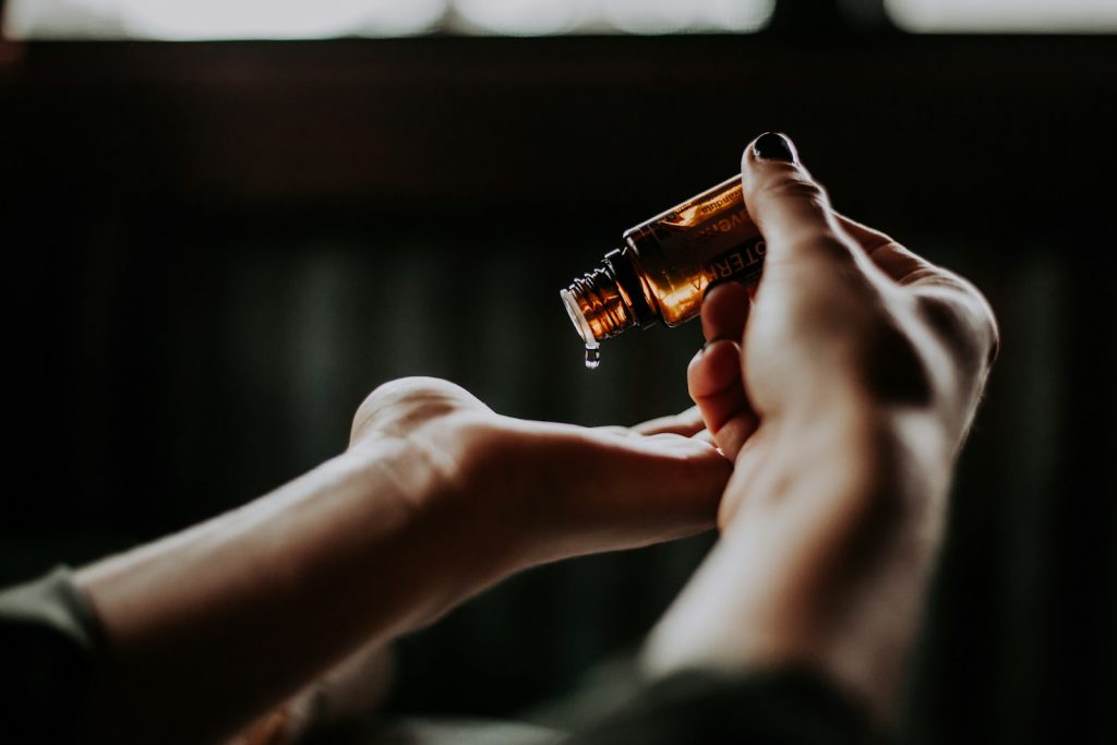 Home 2 person holding amber glass bottle