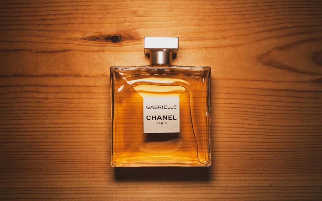 Home 6 Elegant Chanel perfume bottle displayed on a warm wooden surface, showcasing luxury and style.