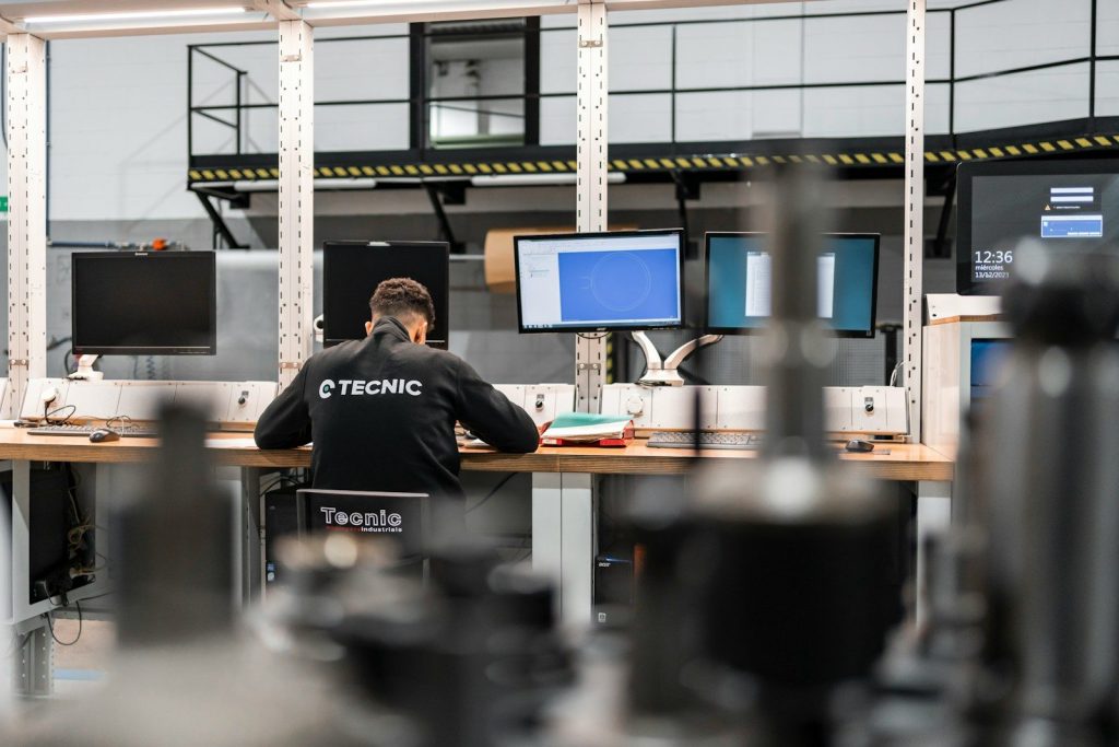 A worker is concentrating at multiple computer screens.